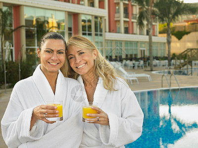 两位女士在酒店泳池边喝果汁图片