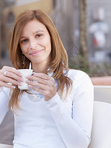 拿着咖啡的年轻女子的肖像图片