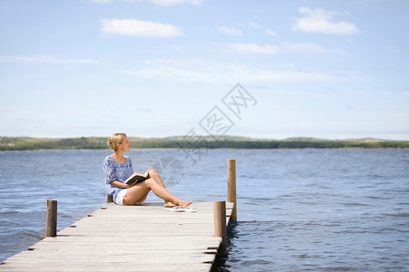 光脚看书坐在湖边的女人背景