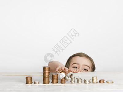 女孩在台面上堆硬币图片