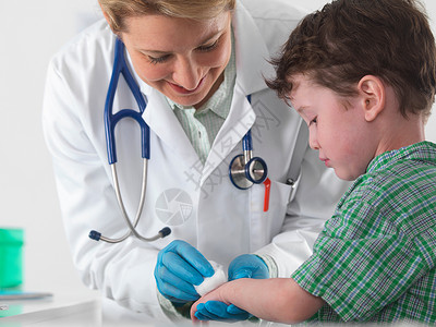 儿科用药医生照顾受伤的小男孩背景
