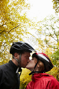 戴自行车头盔的情侣接吻图片