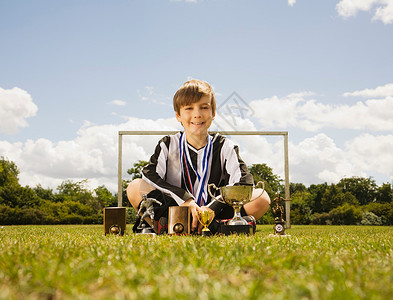 获得奖杯的男孩足球运动员图片
