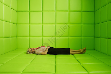 坐在绿色软垫牢房里的女人图片