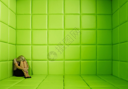 女人蹲在角落里背景图片