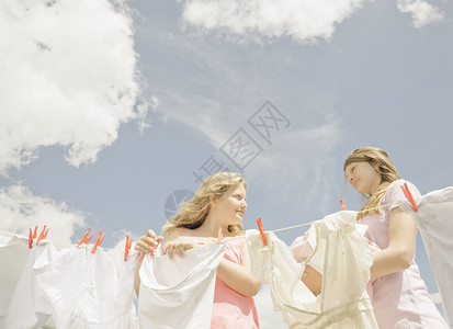 干洗衣女孩们在晾衣绳上晾衣服背景