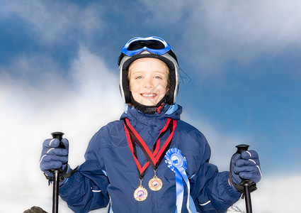 穿着奖牌和滑雪板的男孩图片