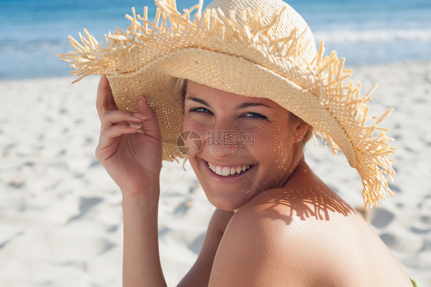 海滩上戴草帽的女人图片