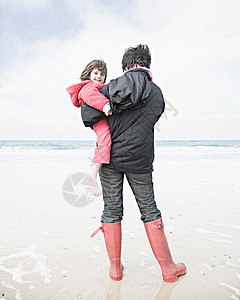 在海滩上抱孩子的女人图片