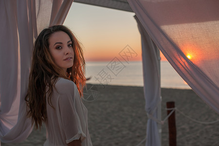 意大利撒丁岛卡斯蒂达斯海滩凉亭下的年轻女子肖像图片