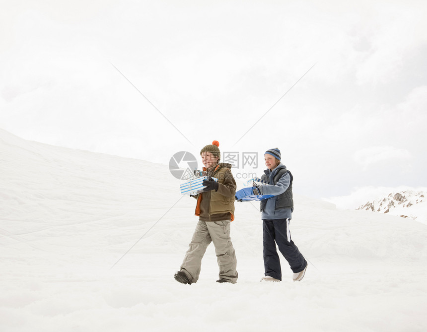 男孩们带着圣诞礼物走在雪地里图片