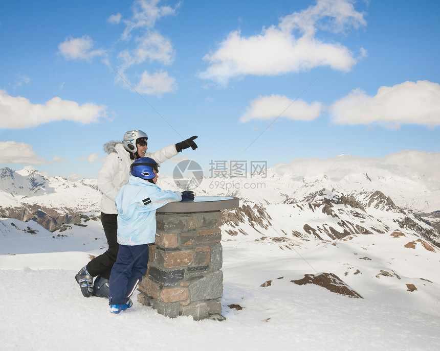 白雪皑皑的山景中的女人和男孩图片