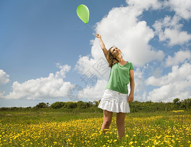 草地上拿着气球的女人图片