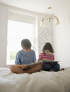 男孩和女孩在床上看书图片