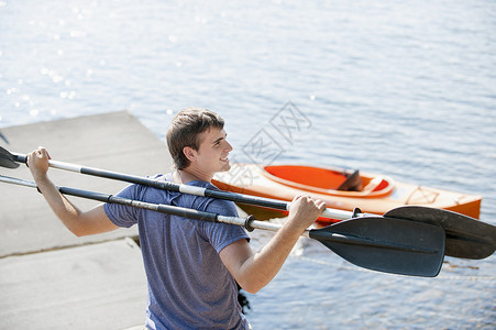 扛着独木舟桨的年轻人图片