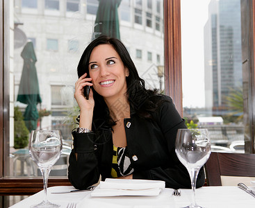 在餐馆里的打手机的女人图片
