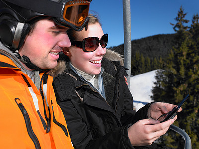一对夫妇在滑雪缆车上玩游戏图片
