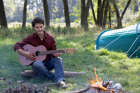 在营地弹吉他的人图片