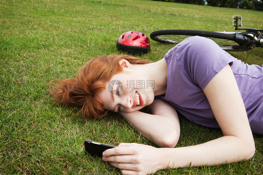 女人躺在草地上发短信图片