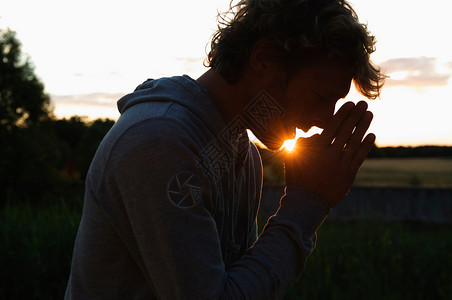 日落时祈祷的人的轮廓图片