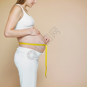 带卷尺的妊娠肿块，轮廓背景图片