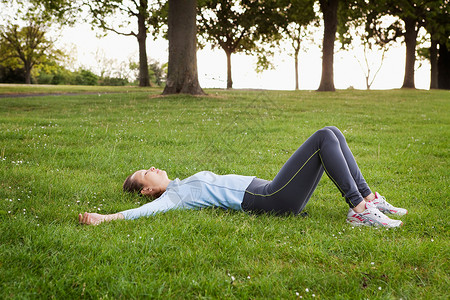 女人躺在公园的草地上图片