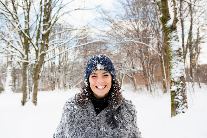 在白雪皑皑的树林里散步的女人图片