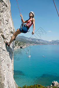 挑战不平凡女子攀岩，背景为海湾背景