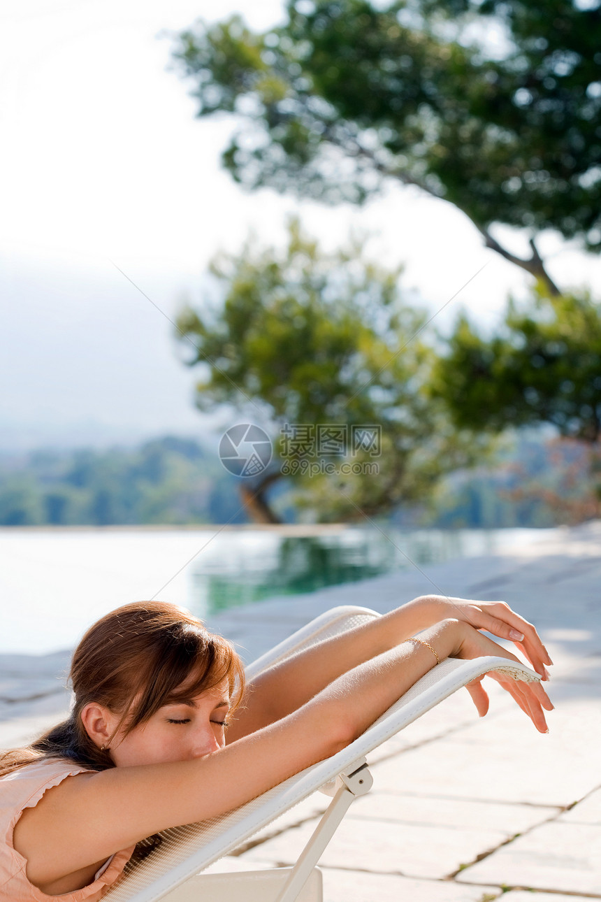 在泳池边放松的女人图片