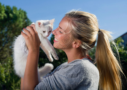 抱着小猫的年轻女子微笑着图片