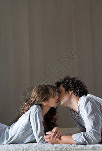 年轻夫妇躺在地板上亲吻图片