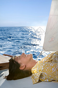 大太阳下躺在帆船上的女人背景图片