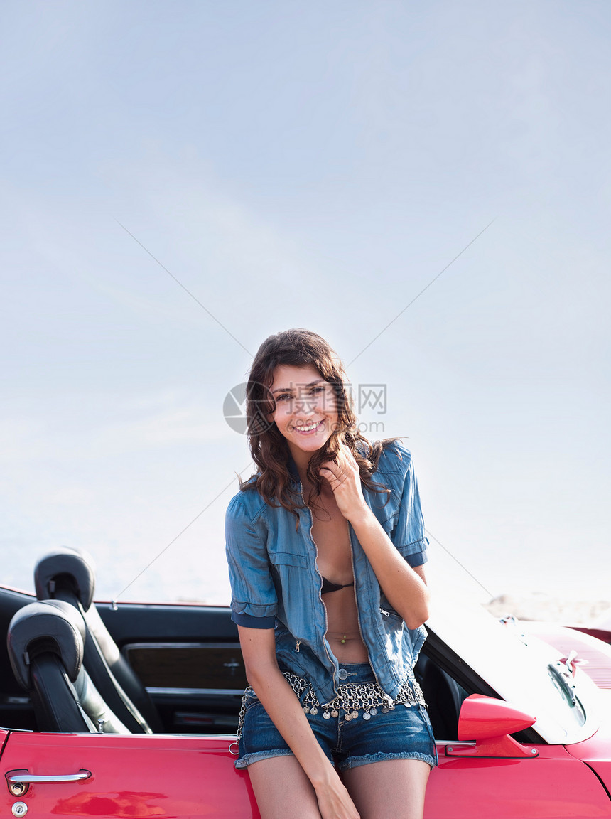 女人斜靠在车旁微笑图片
