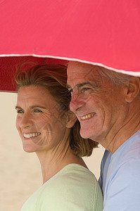 在沙滩伞下的夫妇图片