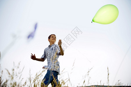 抓气球抓着气球跑的男孩背景