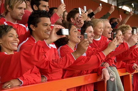 在足球比赛中拍照的球迷高清图片