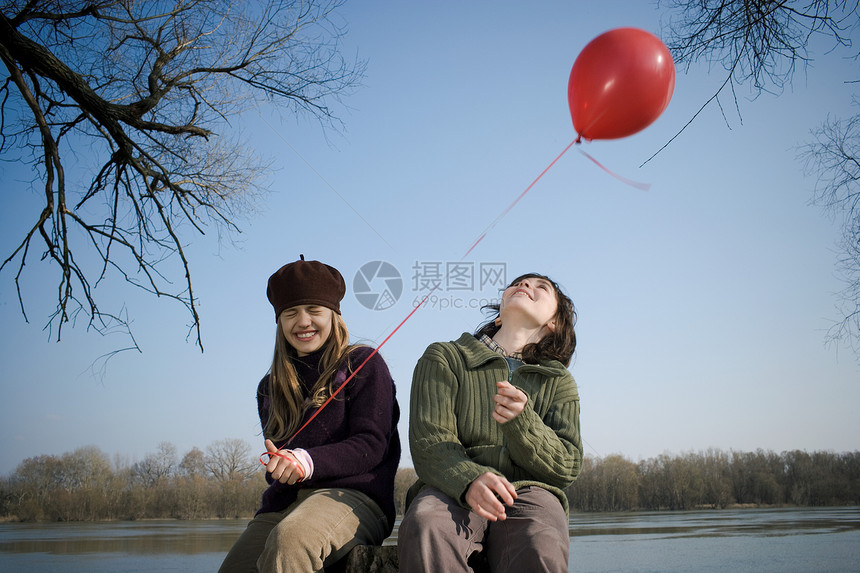 男孩和女孩在河边拿着气球图片