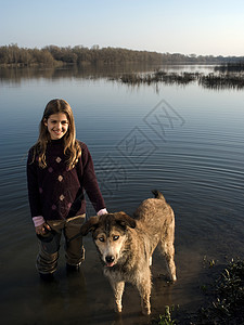 站在河边的女孩牵着狗图片