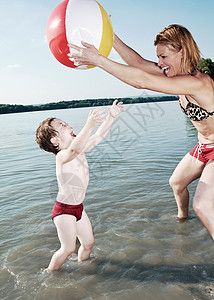 母亲和孩子在湖边玩球图片