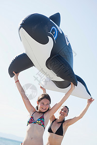女孩鲸鱼举着玩具鲸鱼的女儿和母亲背景