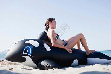 坐在玩具鲸鱼上的小女孩图片