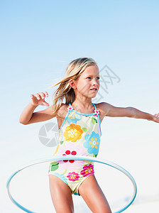 在海滩上玩呼啦圈的小女孩图片