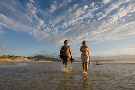 一对夫妇沿着海滩散步图片