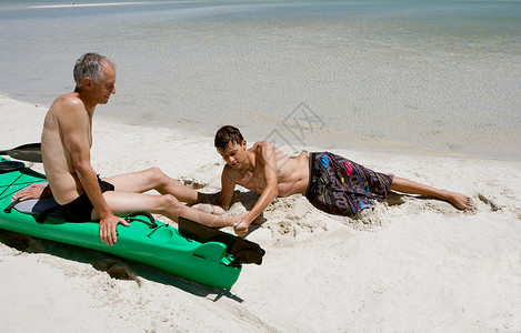 父亲和儿子在海滩上放松图片
