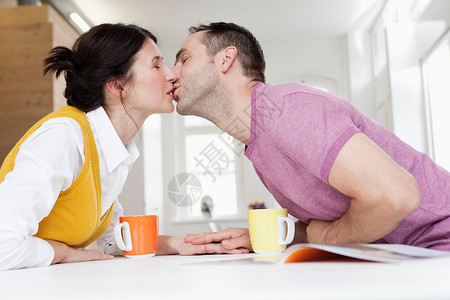 一对夫妇靠在桌子上亲吻图片