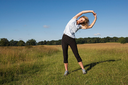 女子跑步运动员在做伸展运动高清图片