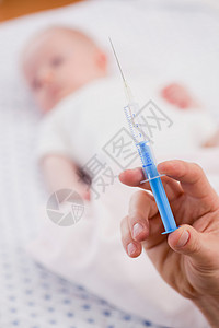 在婴儿面前的手持注射器图片