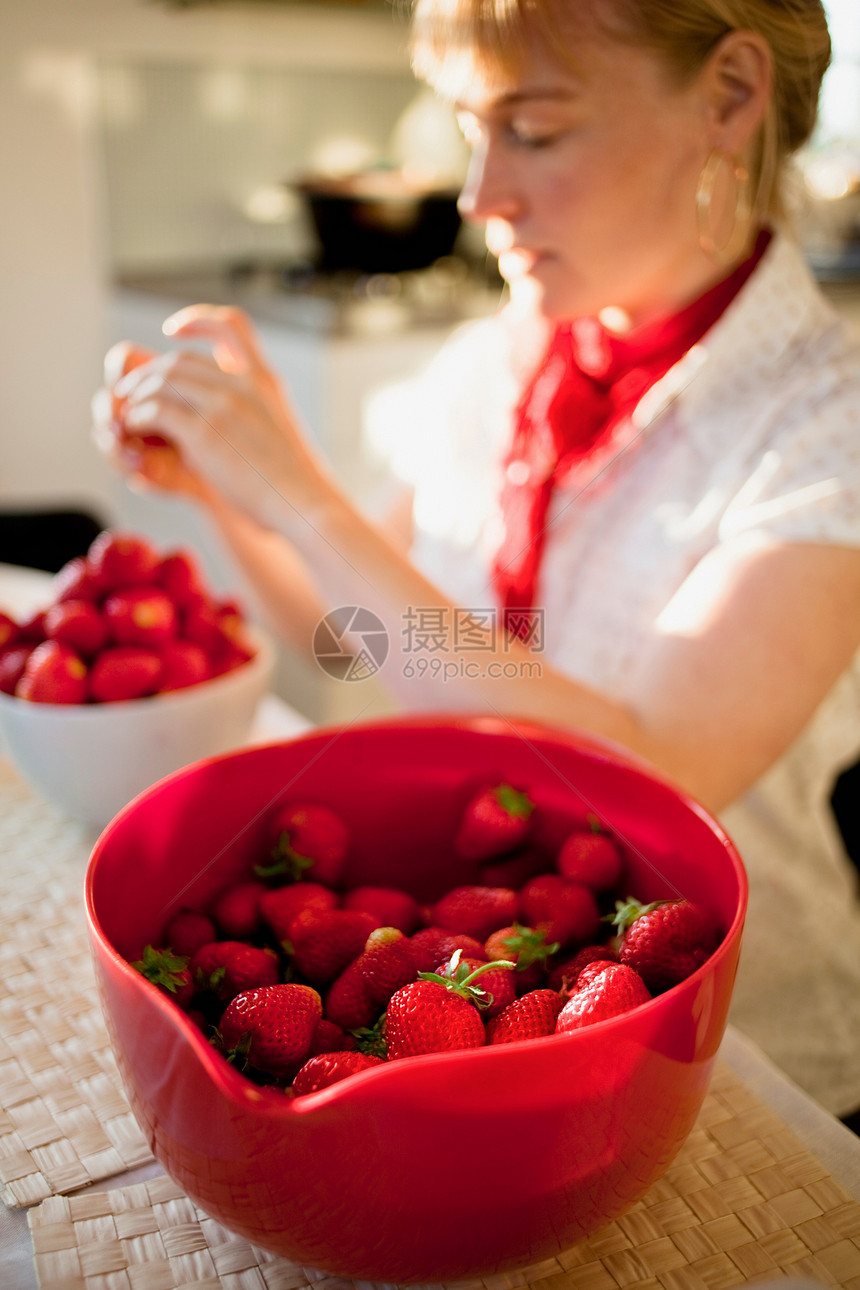 在厨房里摘草莓的女人图片