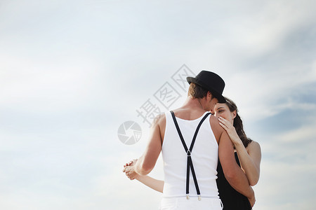 年轻夫妇跳舞在海滩上跳舞的情侣背景