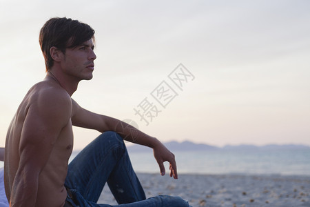 坐在海滩上的男人图片